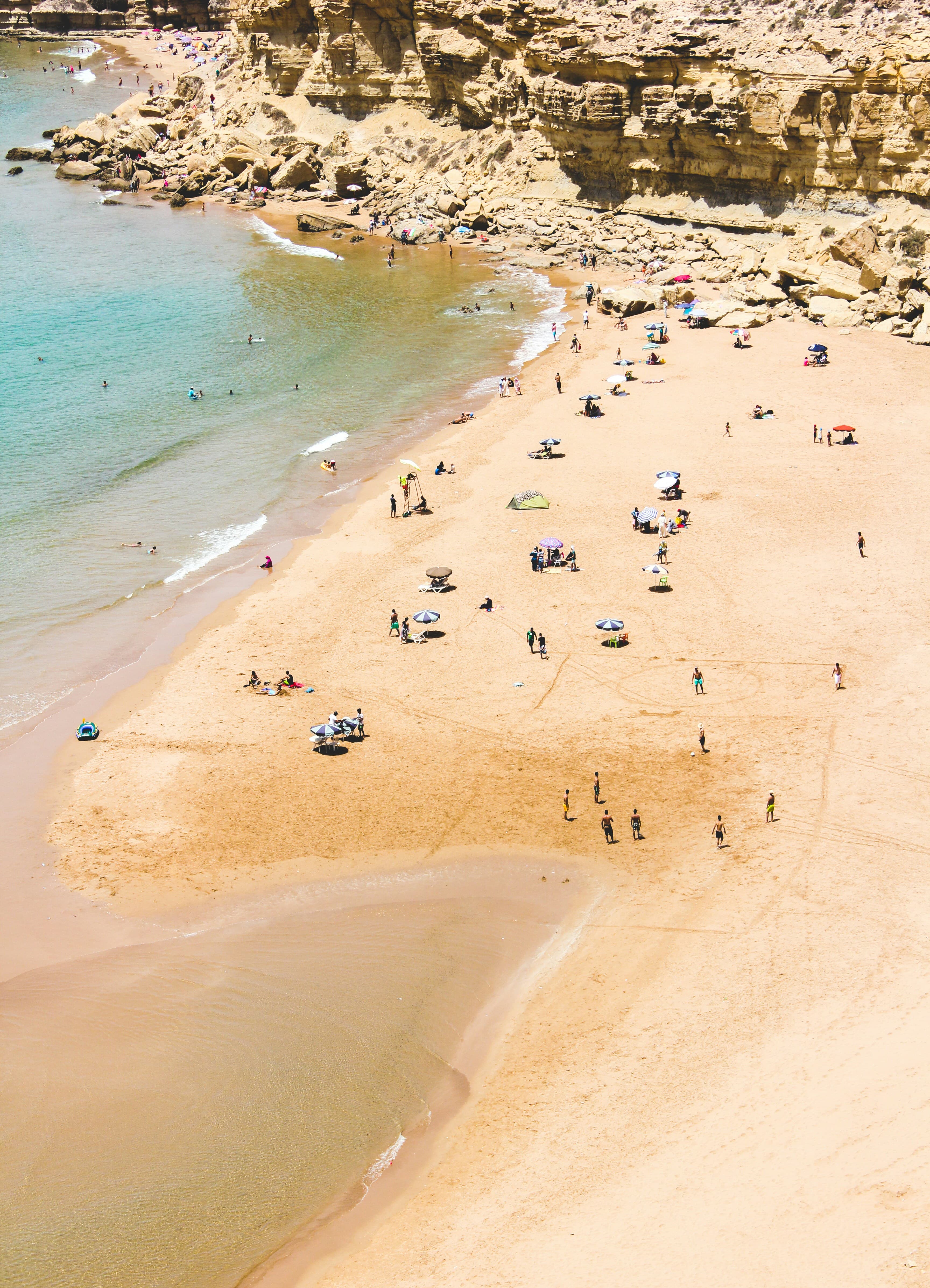 Aerial view of Agadir's sandy beach with swimmers and umbrellas, Morocco
